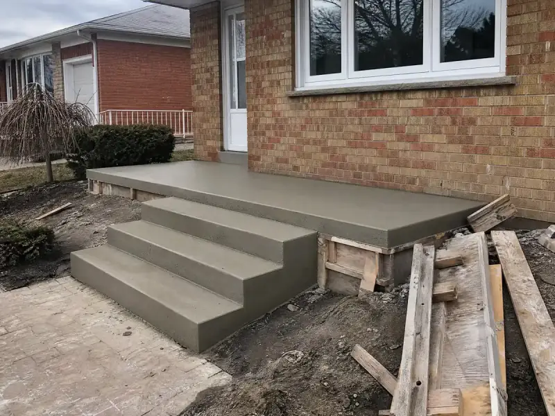 Newly poured concrete front porch steps and landing with a broom finish on a bungalow
