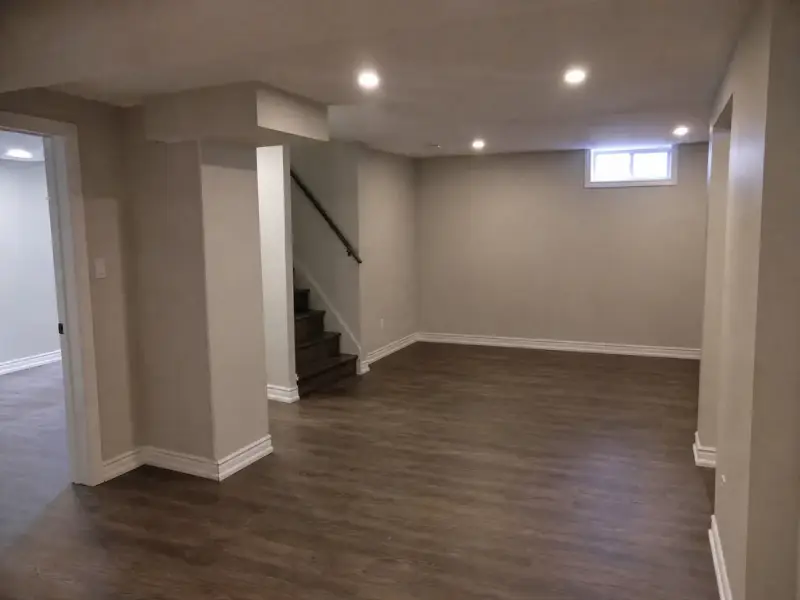 Finished basement room with smooth painted drywall, pot lights and new flooring