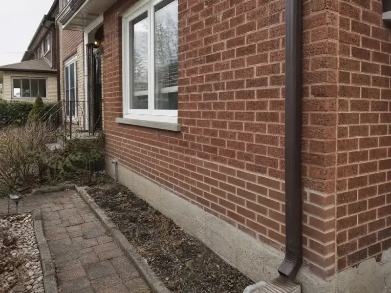 Front wall of a red brick semi after repointing, with clean new mortar joints