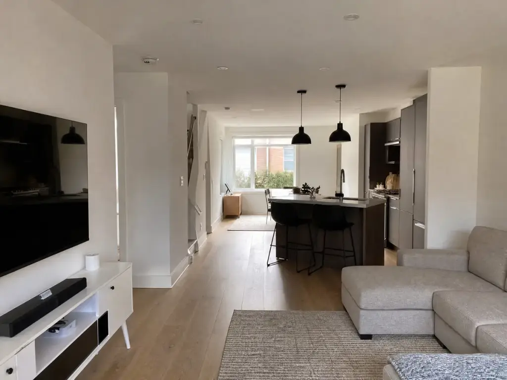 Finished open plan living and kitchen space with pale oak flooring and white walls
